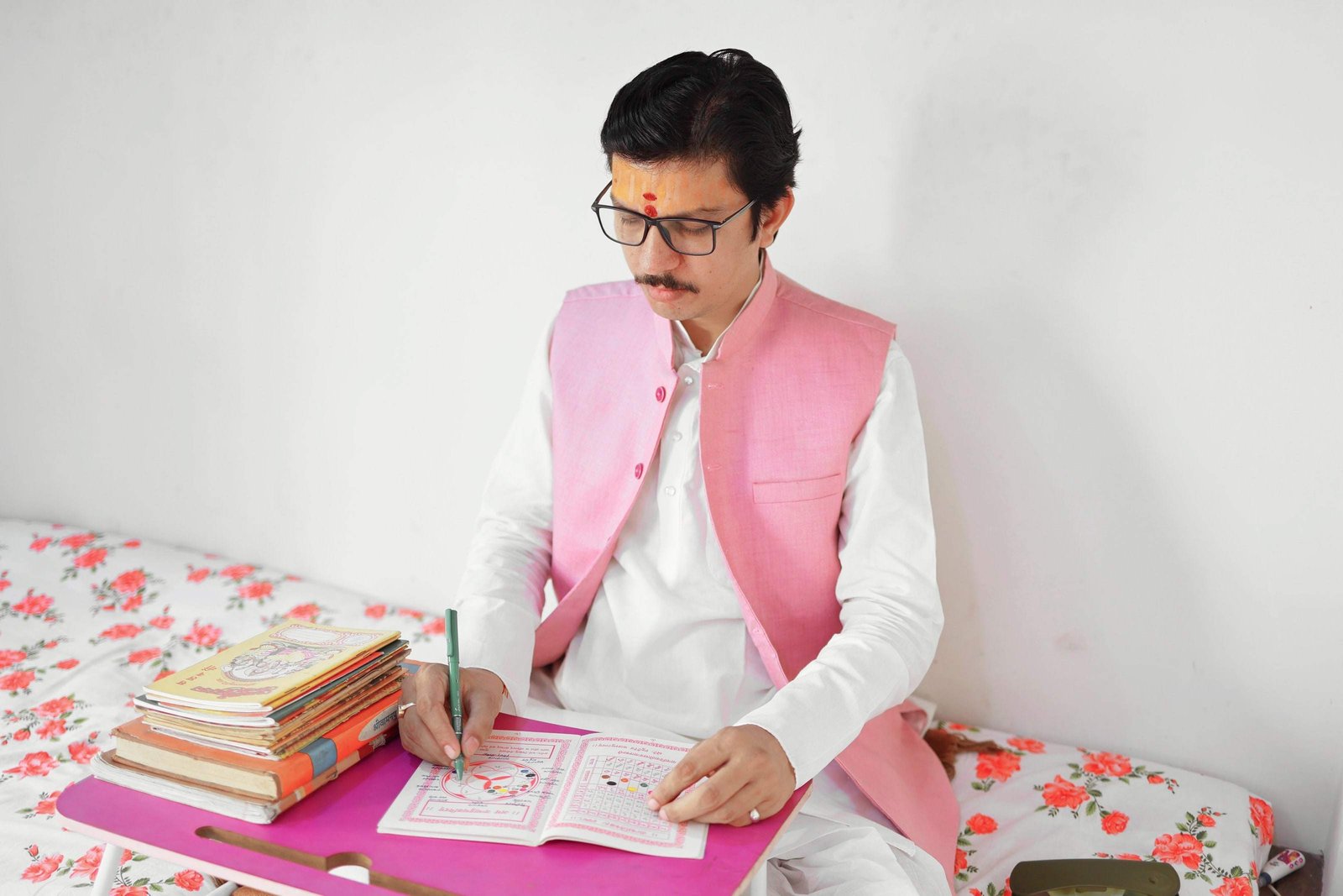 Acharya Ji's hands filling in a Kundli