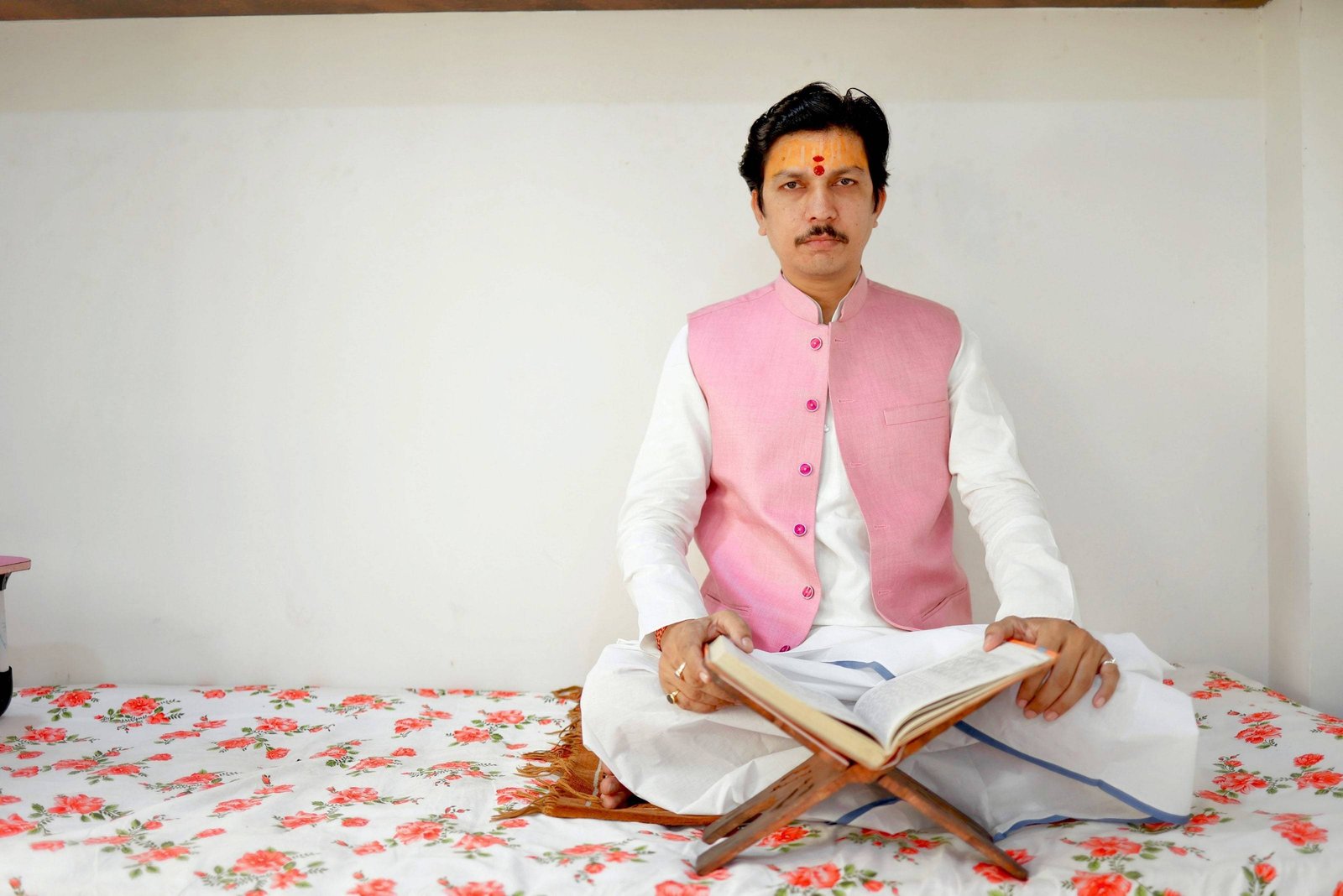 Acharya Neelesh Pandey Ji seated with a Vedic scripture