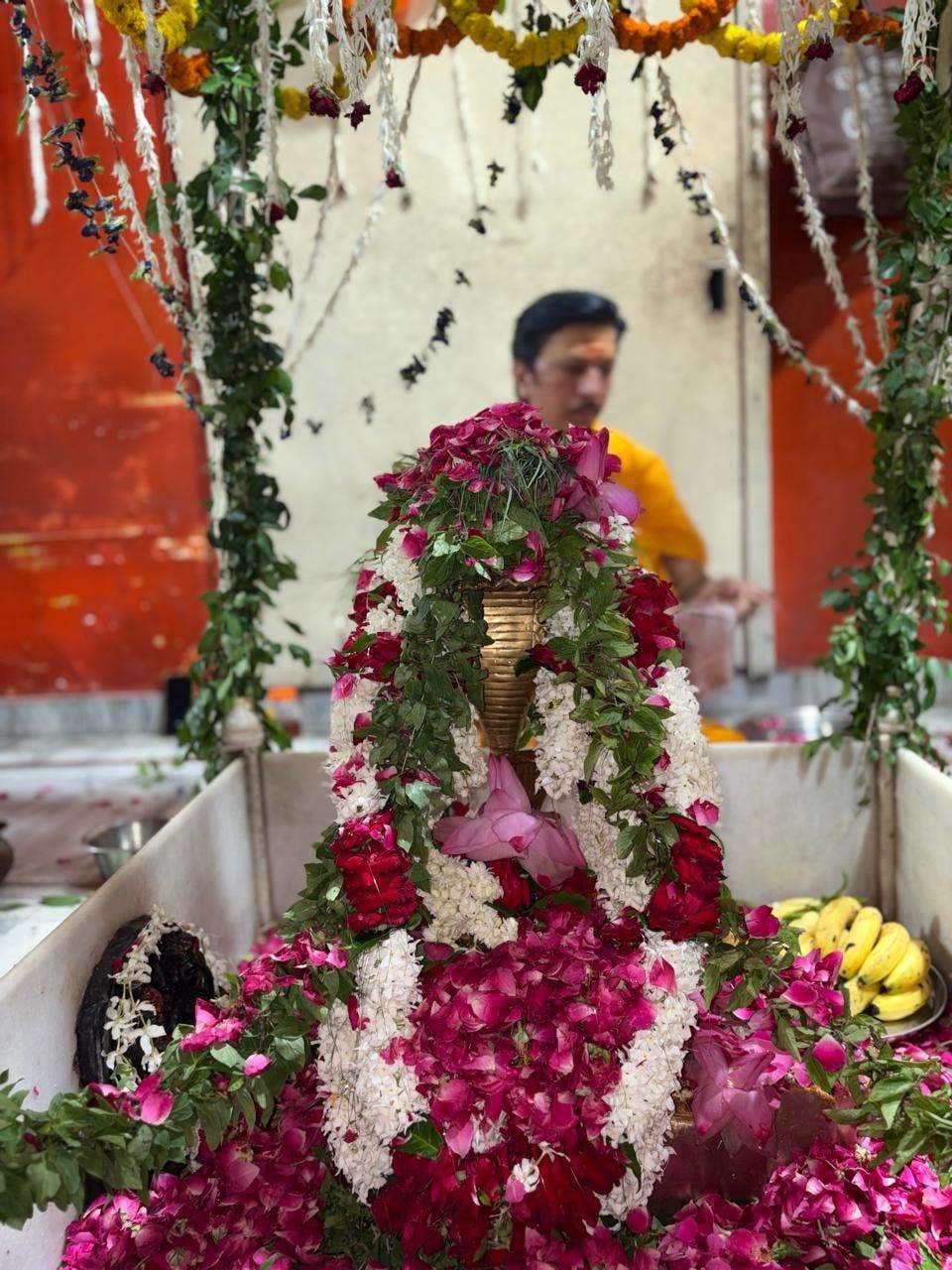 A shrine covered with rose petals and flower garlands at the temple